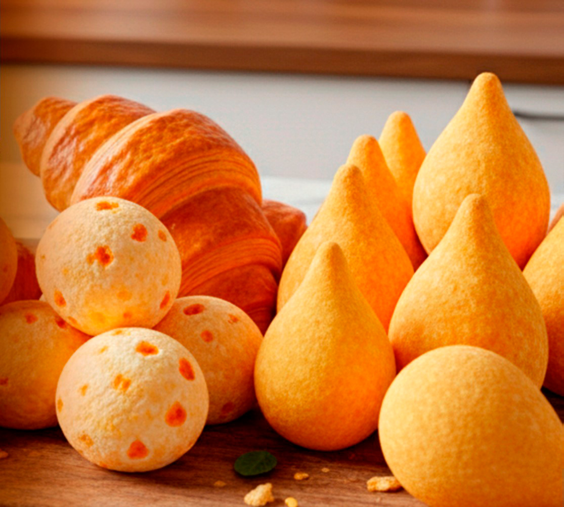 Croissants, pães de queijo e coxinhas em uma tábua de madeira